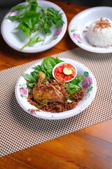 Delicious traditional Indonesian dish with fried chicken and fresh herbs