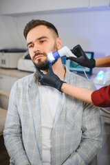 Naklejka premium Man receiving professional beard skin examination at clinic