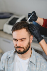Man receiving trichology treatment for hair loss