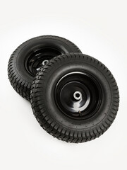 Two wheels from a garden cart on a white background. Black rubber and disc.