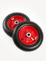 Two wheels from a garden cart on a white background. Black rubber, red disc.