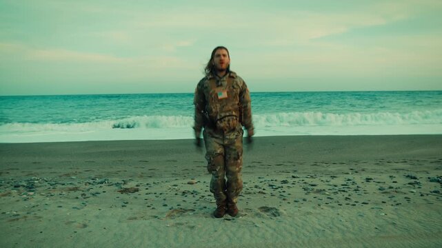American Navy soldier performs a jumping jack exercise on the beach near ocean