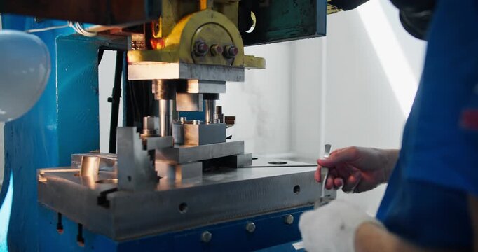 Industrial press machine in operation with worker positioning metal part. factory work and precision tasks performed by production operator