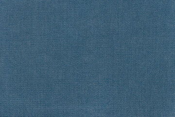 Detailed texture of a corduroy fabric in a rich blue, navy, denim, slate tone. Top view of a ribbed velvet material background with copy space