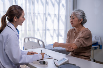 Obraz premium Doctor consulting senior patient about elbow pain