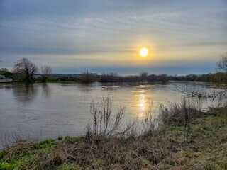 Obraz premium A beautiful sunset over the waterlands at the Attenborough Nature Reserve in Nottingham, UK.
