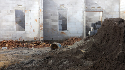 Construction site with a pile of dirt and a concrete building foundation IMG 4380 under development