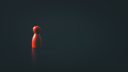 Red wooden figure standing alone in dark background with dramatic lighting symbolizing isolation...