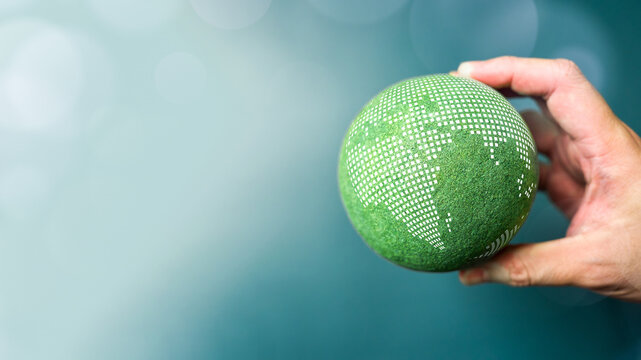 Hand holding green digital globe with pixelated world map symbolizing sustainable technology innovation ESG responsibility and climate action future