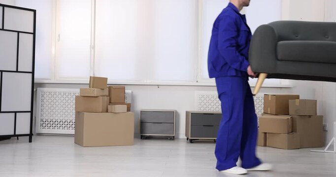 Two mover service workers carrying sofa indoors