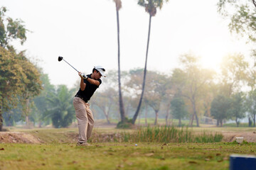Man playing golf in nature golf course, he starting tee off shot