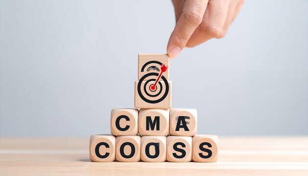 Hand places target icon on wooden blocks spelling CMA and COOSS, symbolizing focused business goals and strategic achievement.