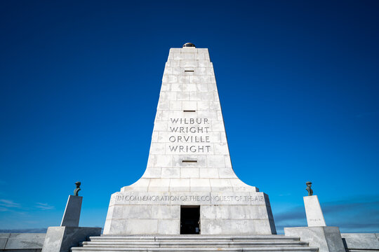 Kill Devil Hills, North Carolina, a low-angle view of the Wright Brothers National Memorial granite pylon under a deep blue sky on the Outer Banks.