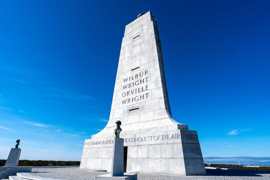Kill Devil Hills, North Carolina, a low-angle view of the Wright Brothers National Memorial granite pylon under a deep blue sky on the Outer Banks.