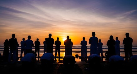 Fototapeta premium Silhouetted people praying or meditating at sunrise or sunset by the ocean, reflecting spiritual devotion and community.