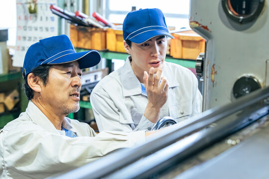 工場で機械を操作する男性作業員のグループ