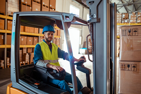 Warehouse worker operating forklift in distribution center