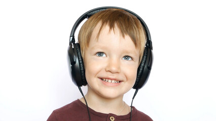 A portrait of a smiling boy with big wired headphones