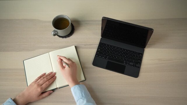Businesswoman multitasking with laptop and tablet at desk