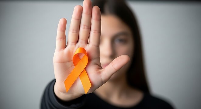 Young woman holds orange ribbon on her palm, symbolizing awareness and support for various causes