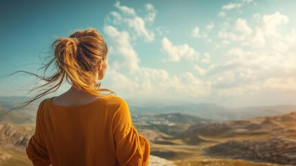 Fototapeta premium Woman gazes at scenic mountain vista, windswept hair