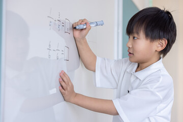 ホワイトボードに分数を書き込む小学生