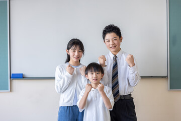 ホワイトボードの前でガッツポーズする3人の子ども