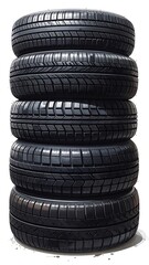 Stacked dark car tires show deep treads, isolated on white background, with a slight shadow