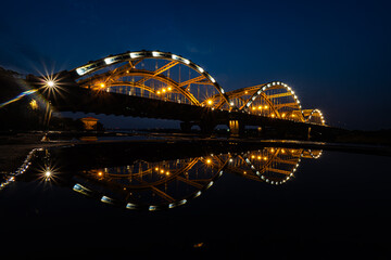 Obraz premium Dong Tru Bridge at Night in Hanoi, Vietnam – Long Exposure with Light Reflection