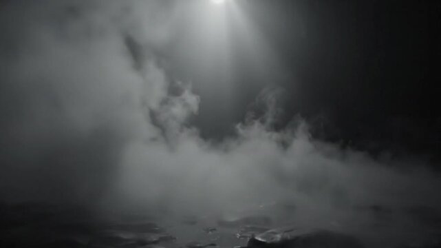 Dramatic landscape of fog or smoke illuminated by a light source from above against a dark