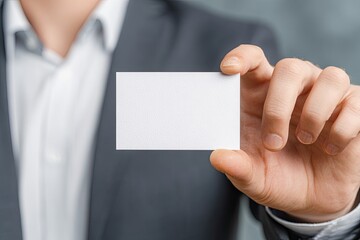 A professional in a suit holds and presents a blank white card