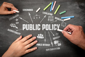 Public Policy Concept. Human Hands with Pieces of Chalk on a Dark Chalkboard Background