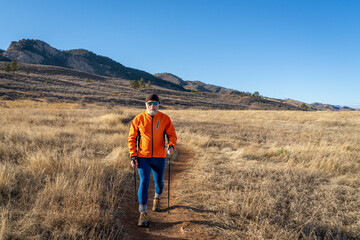 senior male hiker with trekking poles on a trail in Lory State Park in Colorado foothills