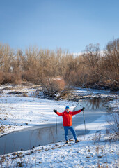 senior man is Nordic walking  along the Poudre River in Colorado, cold winter scenery