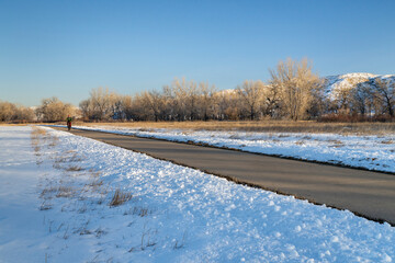 male cyclist commuting on a bike trail in winter scenery - Poudre River Trail in northern Colorado between WIndsor and Greeley