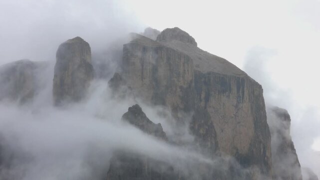 fog rolling in during rain storm in the italian alps (dolomites val gardena) ortisei passo sella (foggy misty cloudy day grey gray sky) dramatic mountains hike travel tourism italy
