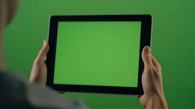 Close-Up Hand Holding Tablet with Touch Gestures on Green Screen