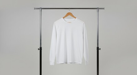 White long-sleeve t-shirt mockup on a wooden hanger, displayed on a clothing rack against a plain studio background for apparel branding and product presentation