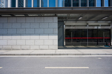 Modern office building entrance with gray stone facade and urban street view