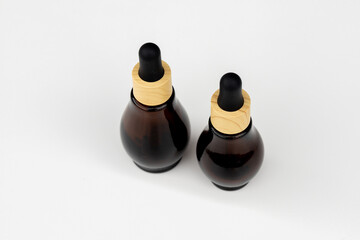 Amber Glass Dropper Bottles with Wooden Caps on White Background