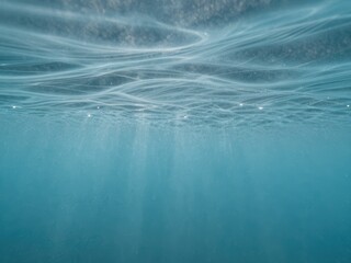 Cerulean underwater light rays with gentle waves surface