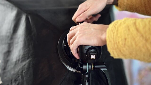 Close‑up shot of a man installing a flash in a softbox