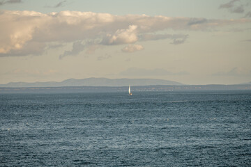Sailboat navigating Atlantic sea under cloudy Cascais sky