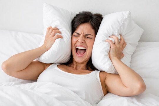Distress in Repose: A woman in distress, cocooned within the sanctuary of her bed, uses pillows to shut out external stimuli. Capturing the raw emotion of disturbance and sleep disturbance.