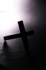Obraz premium Dramatic Silhouette of Wooden Cross with Moody Lighting in Spiritual Setting