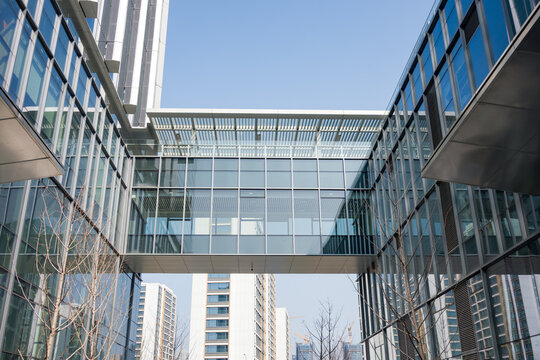 Modern glass skybridge connecting two office buildings in an urban business district