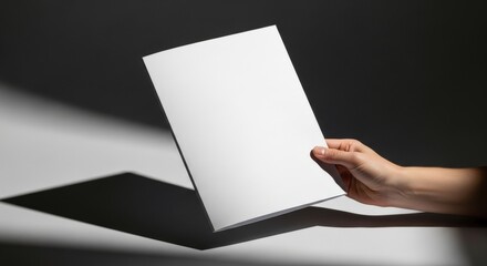 Naklejka premium Hand holding white paper on black background.