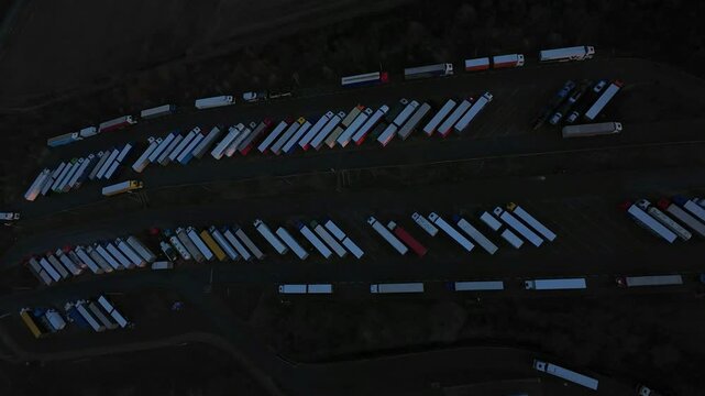 Nighttime Vehicle Transfer Station. Night Shift Cargo Consolidation And Delay Management Zone. Late Evening Transport Hub Managing Waiting Trucks And Scheduling Disruptions Efficiently