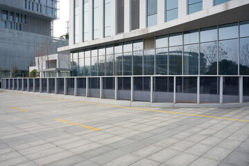 Modern office building with glass curtain wall exterior and paved plaza area