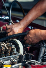 Obraz premium Vertical Mechanic man hands repairing car shop. Man hands fixing Car machinery vehicle mechanical service. Vertical horizon vehicle hood checking automobile. Car motor Workshop oil garage maintenance
